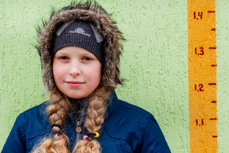 The girl is warmly dressed. Teenager in a warm jacket. Concept for seasonal clothing in winter, autumnの写真素材