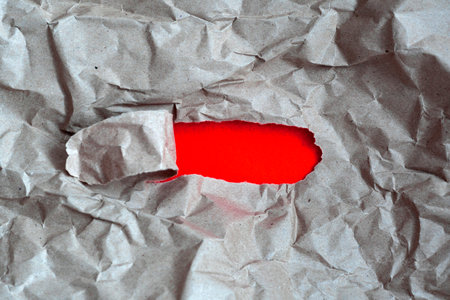 hole in paper with color paper background inside. Good paper texture.torn hole in paper.paper ripped to create a holeの写真素材