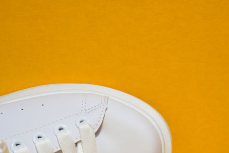 white sneaker, colored yellow, orange, background. sport shoes, Lifestyle sneaker sport shoe. Stylish white sneaker. Copyspace. top viewの写真素材