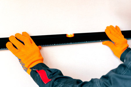 Worker's hands with bubble level. measuring with bubble level.Measurement accuracy concept, modern...