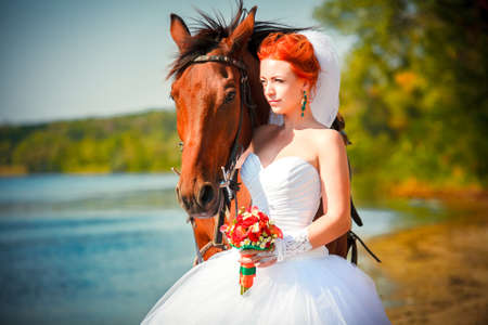 Portrait of beautiful bride with horseの写真素材