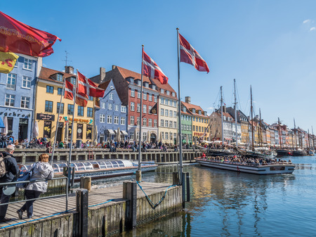 Lovely Nyhavn port in Copenhagen city centre with Danish flags in the front.のeditorial素材