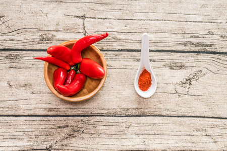 Red pepper and paprika spice in small spoon on a wooden backgroundの写真素材