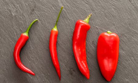 Red pepper and paprika spice in small spoon on a wooden backgroundの写真素材