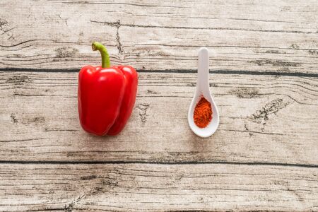 Red pepper and paprika spice in small spoon on a wooden backgroundの写真素材