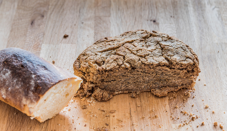 Delicios home made rye bread and regular white bread on a wooden board.の写真素材
