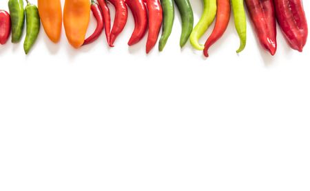 A mix of various sized peppers on a white background.の写真素材