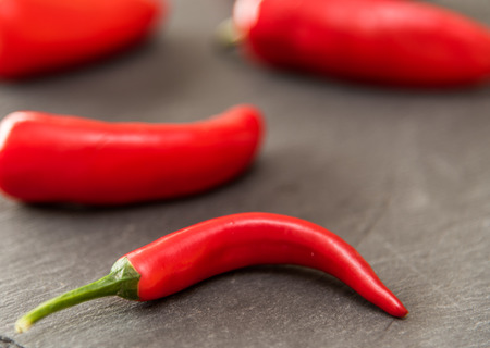 Red peppers on a slate plate backgroundの写真素材