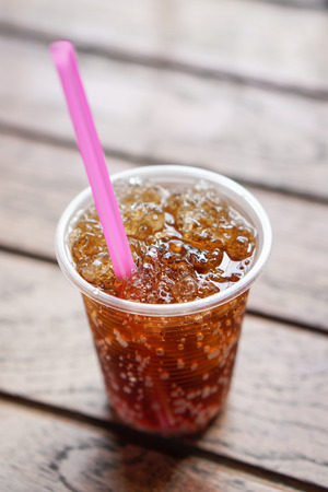 glass of cola with ice with wood background.の写真素材