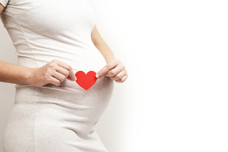 Young, pregnant woman on white backgroundの写真素材