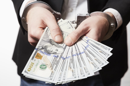 Man in handcuffs with money.