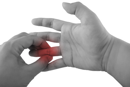 Pain in a finger. holding hand to spot of finger pain.の写真素材