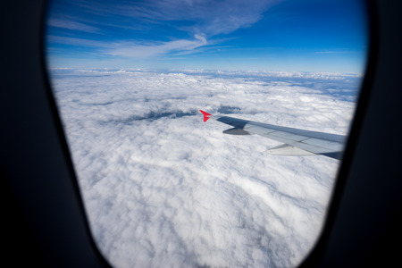 Looking through window aircraft during flight in wing with a blue skyの写真素材