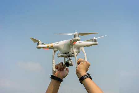 Hand holding Drone flying helicopter with cameraの写真素材