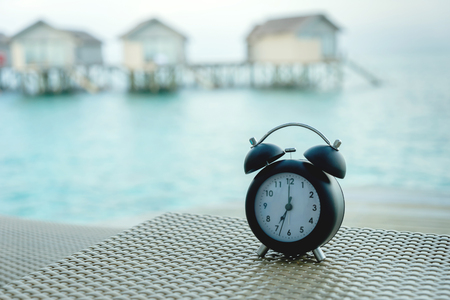 classic clock on the chair with sea background
