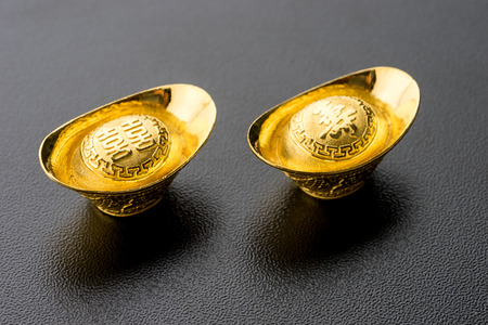 Closeup of big gold on black background. Chinese word mean wealthy and lucrativeの写真素材