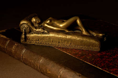 Ancient still-life with bronze odalisque on the old book.の写真素材