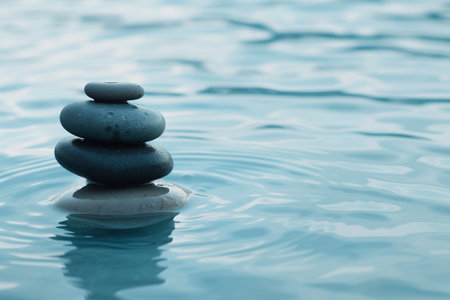 zen stones on blue water background with copy space. Zen concept.の素材