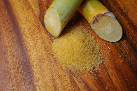brow sugar and sugar cane on wooden backgroundの写真素材