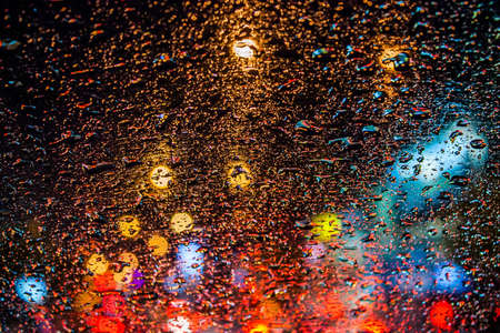 drops of rain on window with bokeh lights