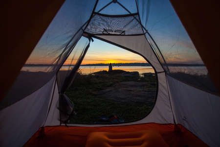 camping tent glow up with sunrise in morningの写真素材
