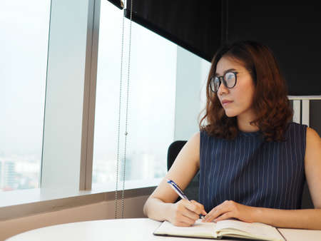 Beautiful woman working near office's windowの写真素材