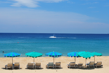 White sand beach with chairs and blue skyの写真素材
