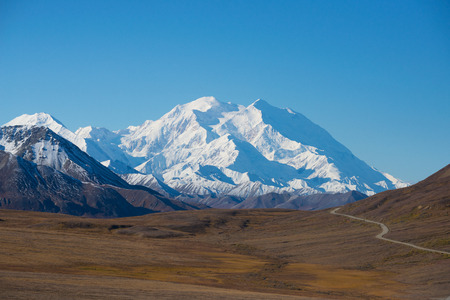 Mount McKinley's snowy peak with the park road and tundra in the foreground, Denali National Park, Alaska, USの写真素材