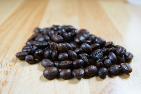 coffee beans and shadow  on wood background,selective focusの写真素材