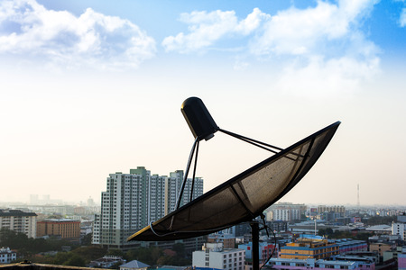 Black satellite dishes on the roof top with sky blueの写真素材