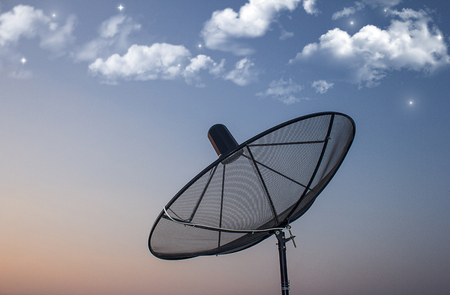 Black satellite dishes on the roof top with sky blue,night,starの写真素材