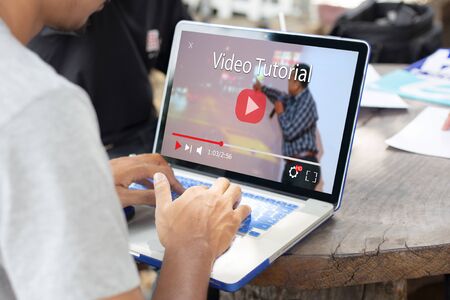 Online video tutorial concept.Man using laptop or pc on wooden table