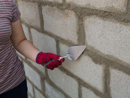 Bricklayer with block brick at a construction site  の写真素材