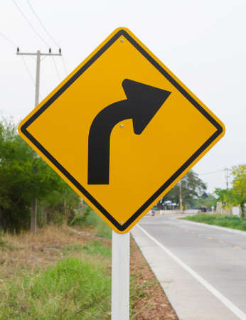Curved Road Traffic Sign on the road at country sideの写真素材
