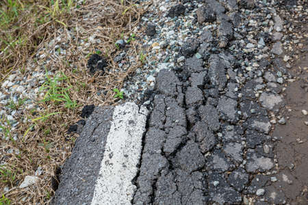 Asphalt surface, the curve of the road were demolished due to poor construction.の写真素材