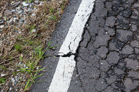 Asphalt surface, the curve of the road were demolished due to poor construction.の写真素材