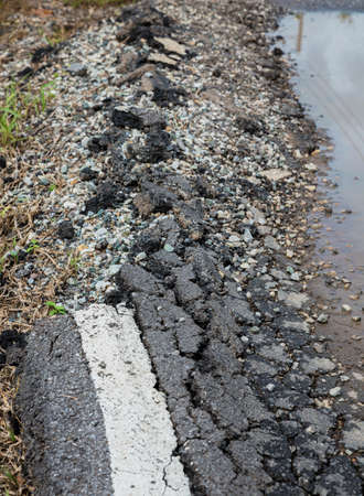 Asphalt surface, the curve of the road were demolished due to poor construction.の写真素材