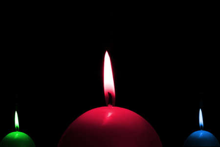 Three multicoloured candlesの写真素材