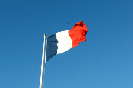 French flag on a sunny autumn day against a blue skyの写真素材