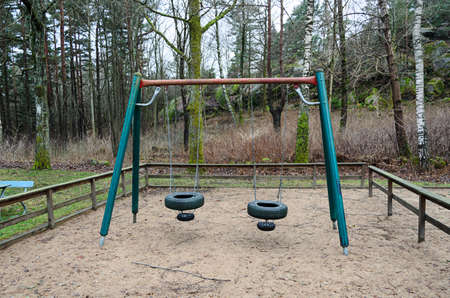 out toy swing located on playground in the woods