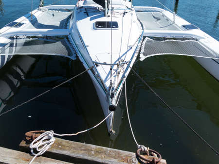 Trimaran at the pier awaiting p sailing out on the oceanの写真素材