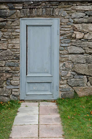 one old and grey door in the stone wall at Gunnebo castleのeditorial素材