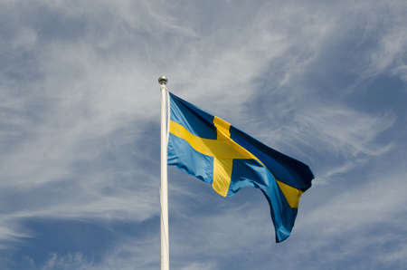 the swedish flag against a blue sky a beutiful summerdayの写真素材