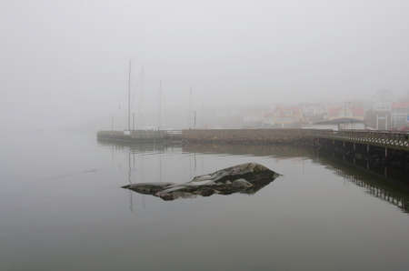 fog on the swedish westcoast the boat is in the harbourの写真素材