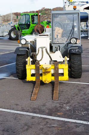 two forklift standing in the harbour and wait to transport boatの写真素材