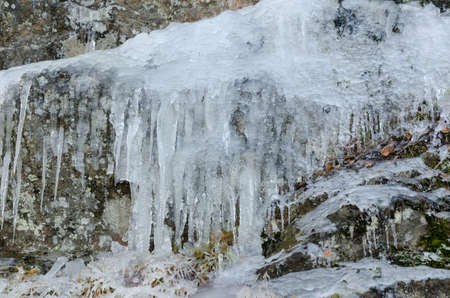 some icicless hanging down from the cliff and have start to dropの写真素材