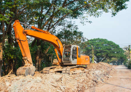 old orange backhoe loader in road construction