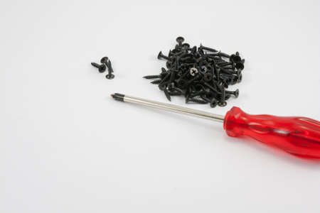 red screw driver and black screw on white background