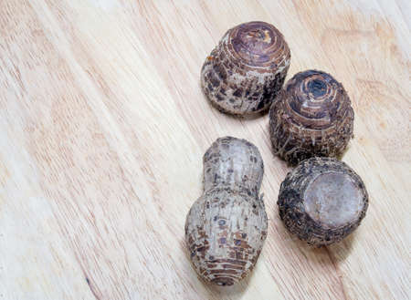 cooked taros with rough shell on wood blockの写真素材