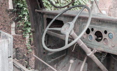 Steering wheel inside an old rusted truck on the side of a road, vintage tonedの写真素材